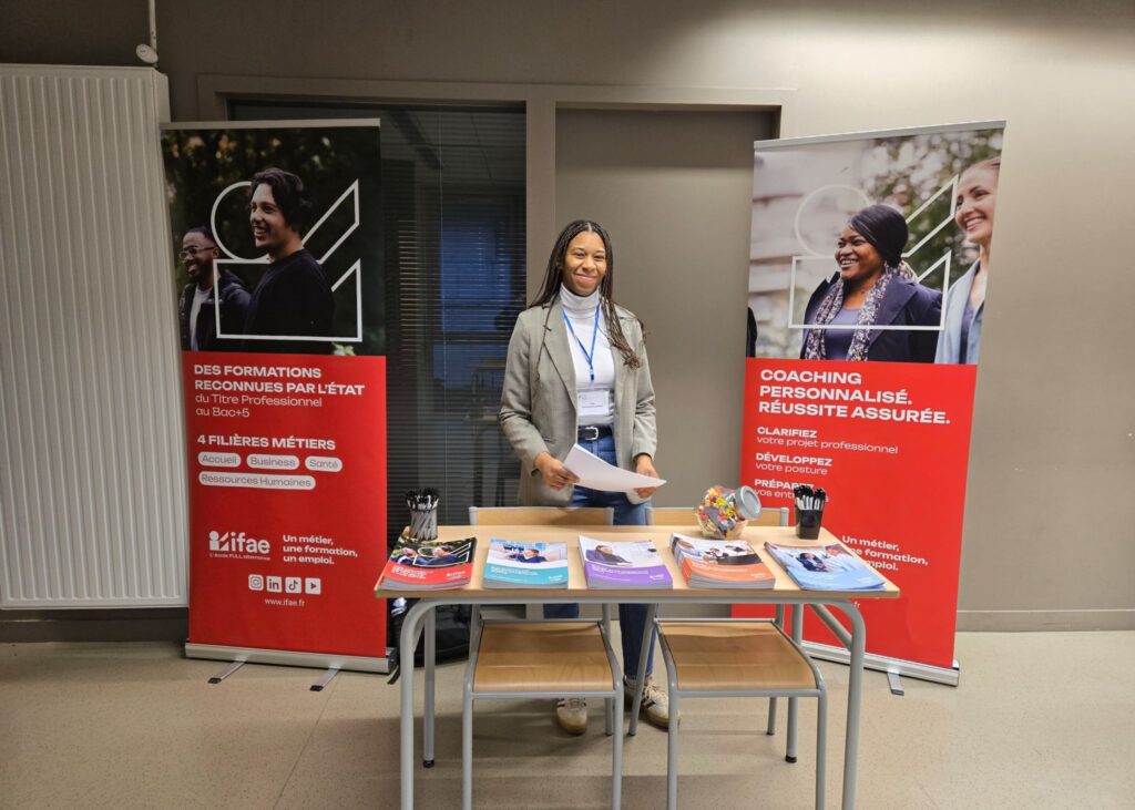 Femme souriante derrière un stand d'information.