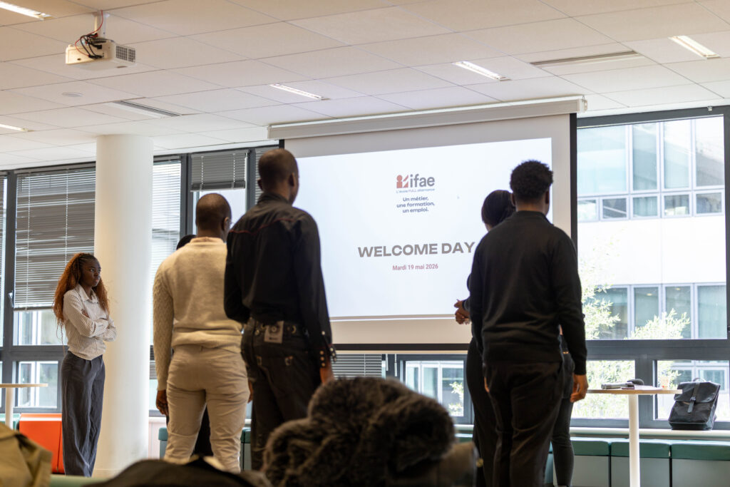 Participants debout devant écran Welcome Day