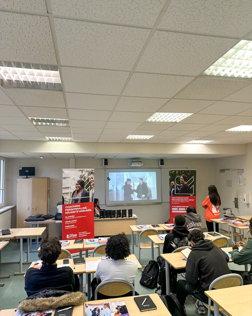 Étudiants en salle de classe avec présentation.