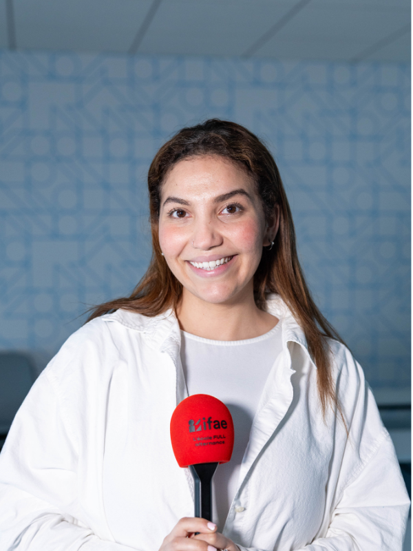 Femme souriante tenant un micro rouge