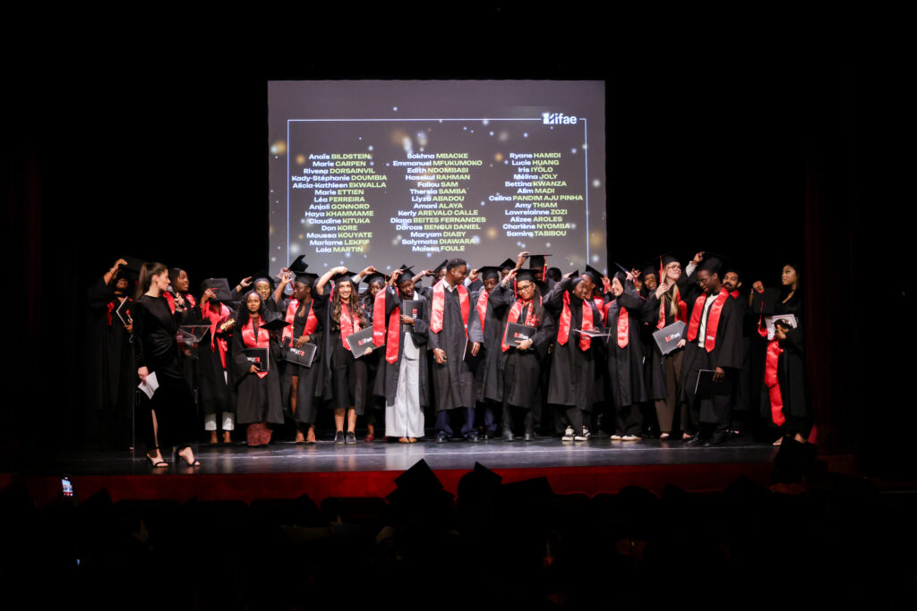 Diplômés célébrant sur scène avec toques et diplômes