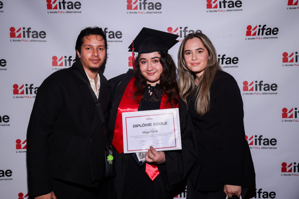 Deux diplômés posent avec un diplôme devant le logo IFA
