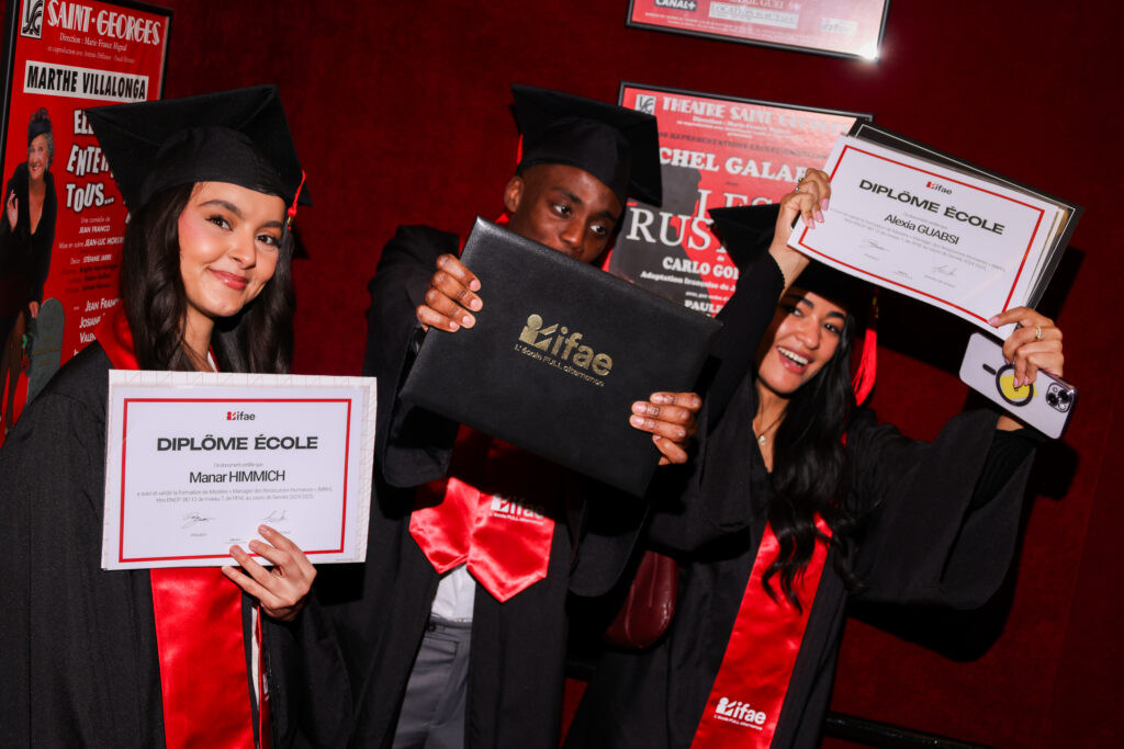 Femme tenant un diplôme devant un fond rouge IFAE