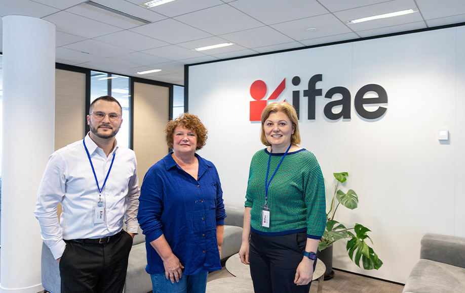 Trois personnes devant un logo d'entreprise.
