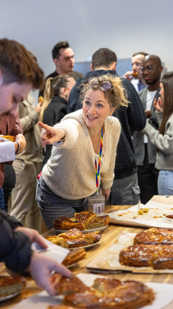 Femme souriante pointant vers une table de galettes.