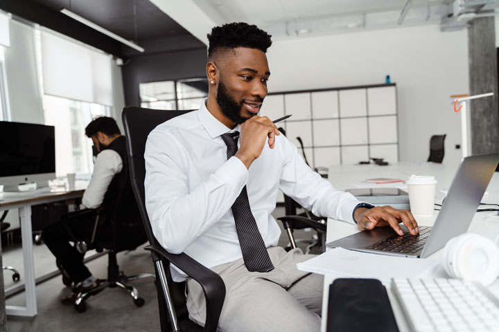 Homme en chemise travaillant sur un ordinateur portable