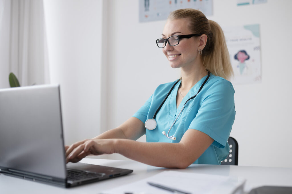Professionnelle de santé souriante travaillant sur ordinateur portable
