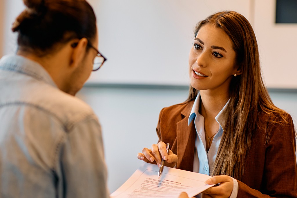 Femme expliquant un document à un homme.