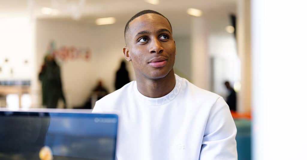 Homme souriant regardant vers le haut, bureau flou.